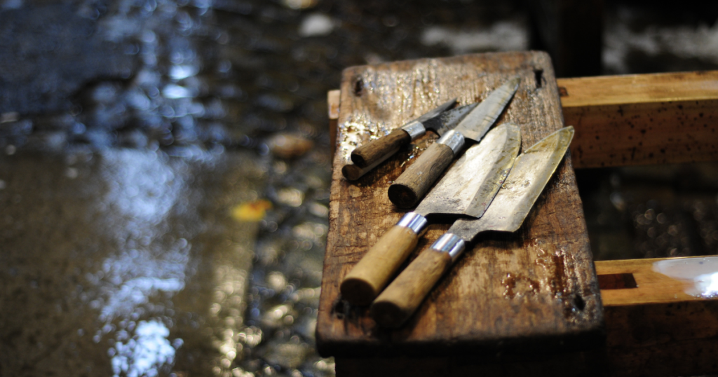 4 damaged knives placed on a wood board