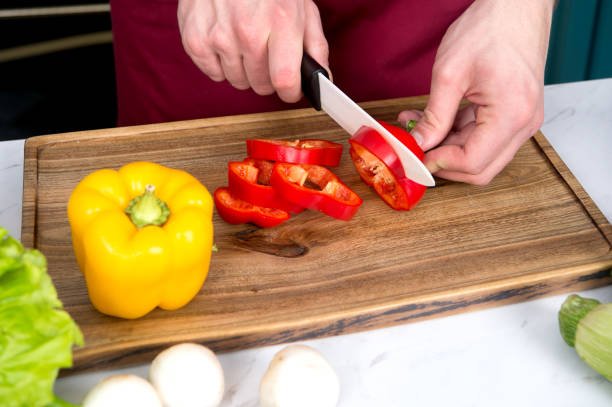 A chef cutting a tomato with ceramic knife