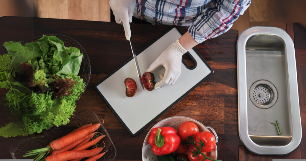 A chef cutting vegetables on a plastic cutting board