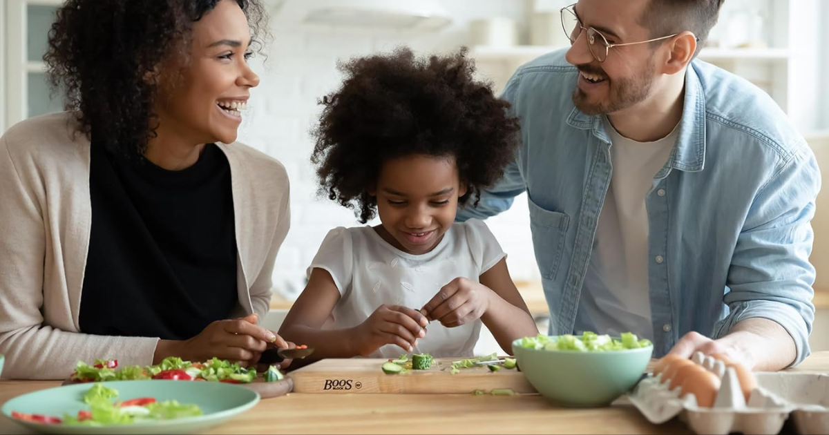 A family happily chopping vegetable on John Boos Cutting board